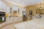 Tasteful granite counter tops are accented by white wood cabinets